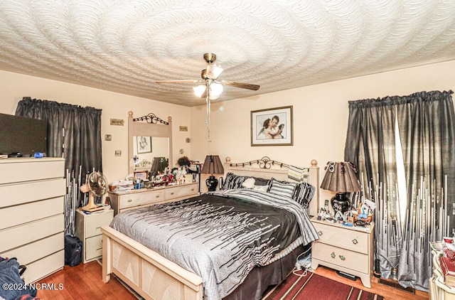 bedroom with dark hardwood / wood-style floors and ceiling fan