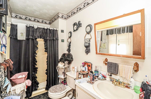 bathroom featuring toilet, walk in shower, and vanity