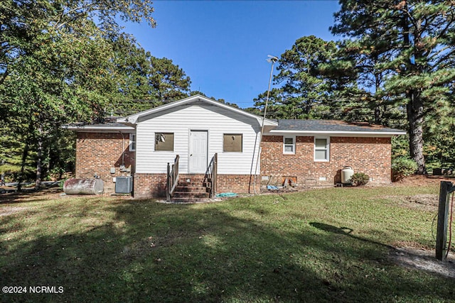 back of house with a lawn and central AC unit