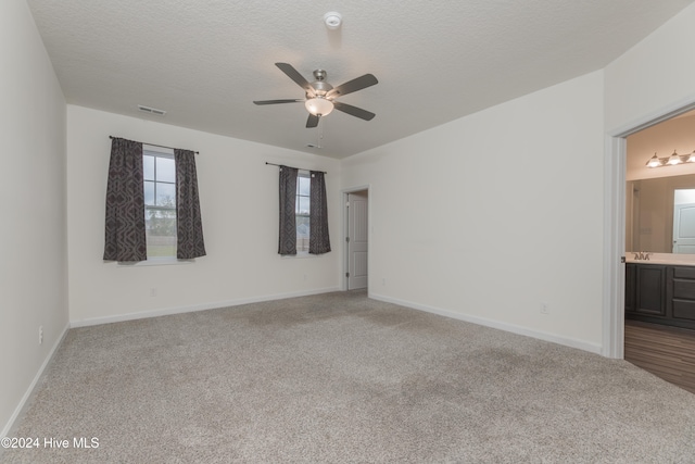 empty room with sink, a textured ceiling, light carpet, and ceiling fan