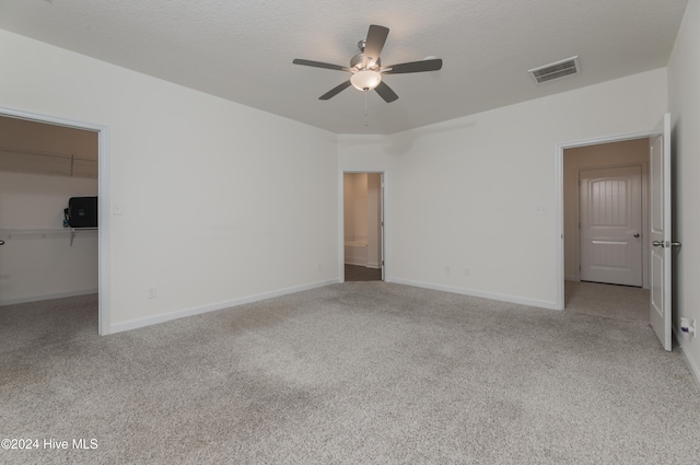 carpeted spare room with a textured ceiling and ceiling fan