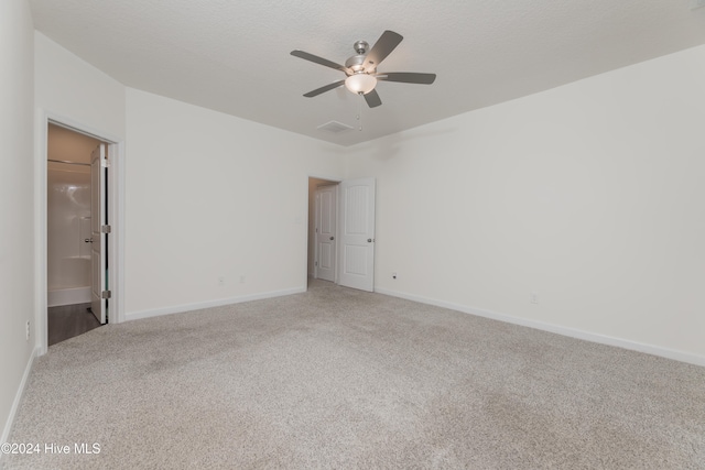 carpeted spare room with ceiling fan and a textured ceiling