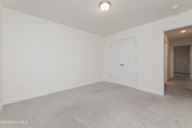 unfurnished bedroom with carpet and a closet