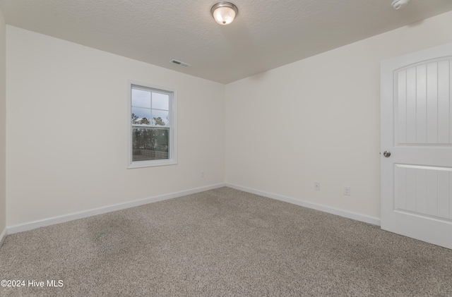 unfurnished room featuring a textured ceiling and carpet floors