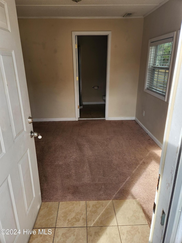 empty room with light carpet and crown molding