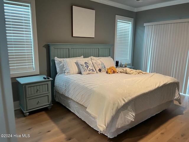 bedroom with ornamental molding and wood-type flooring