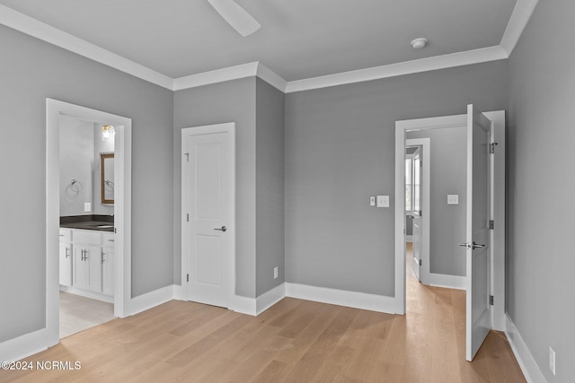 unfurnished bedroom featuring light hardwood / wood-style floors, ceiling fan, crown molding, and connected bathroom