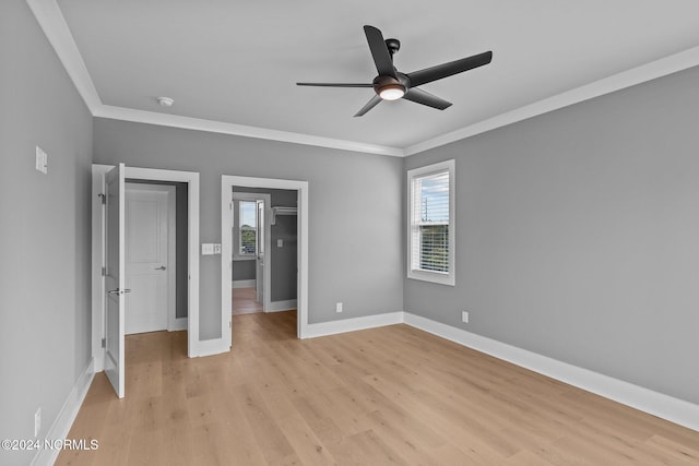 unfurnished bedroom featuring light hardwood / wood-style flooring, multiple windows, crown molding, and ceiling fan