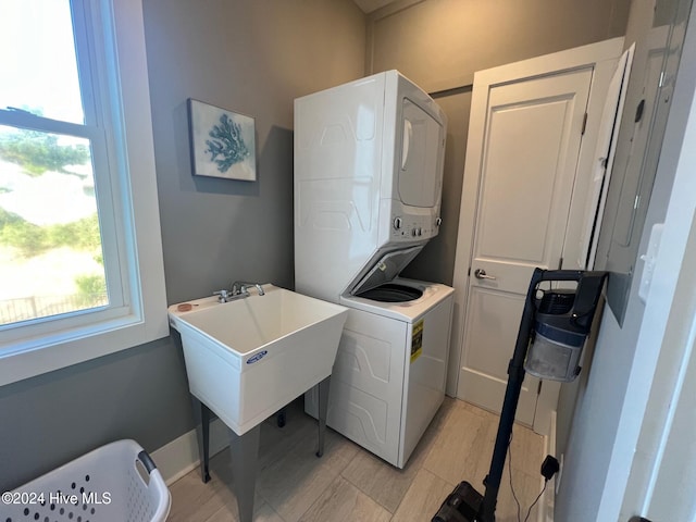 clothes washing area featuring stacked washer / dryer