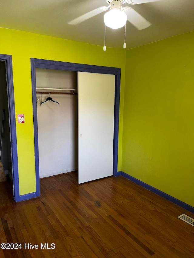 unfurnished bedroom featuring dark hardwood / wood-style flooring, a closet, and ceiling fan