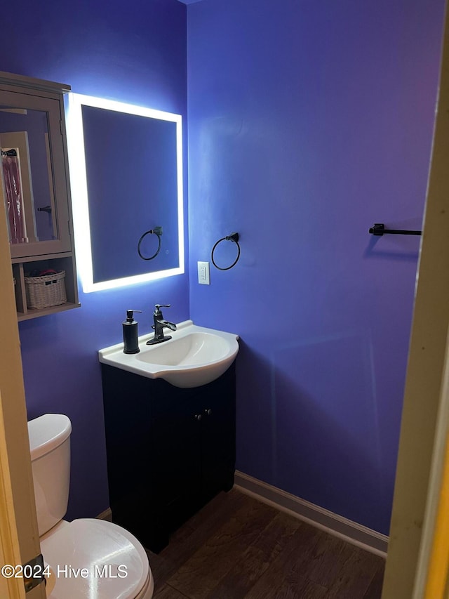 bathroom with vanity, toilet, and hardwood / wood-style floors