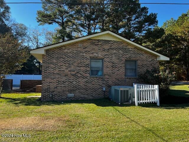 view of home's exterior with a yard and cooling unit