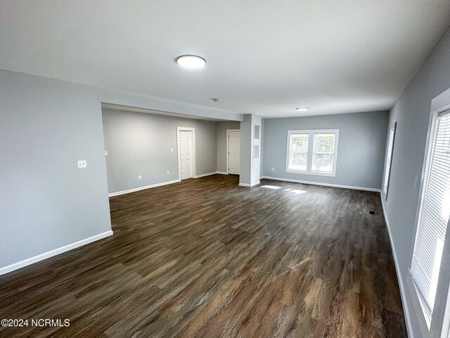 unfurnished living room featuring dark wood-type flooring