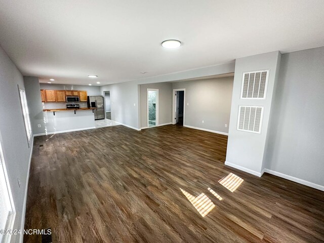 unfurnished living room with dark wood-type flooring