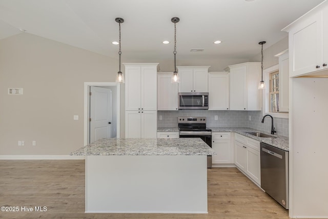 kitchen with sink, decorative light fixtures, a center island, and appliances with stainless steel finishes