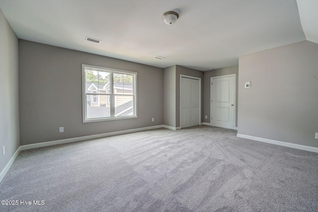 unfurnished bedroom featuring baseboards, visible vents, and carpet