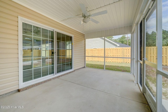 unfurnished sunroom with ceiling fan