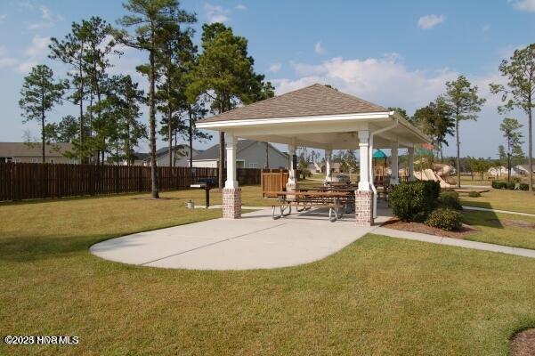 view of property's community with a lawn, a gazebo, and fence