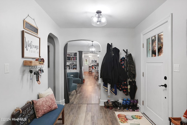 foyer entrance with wood-type flooring and a notable chandelier