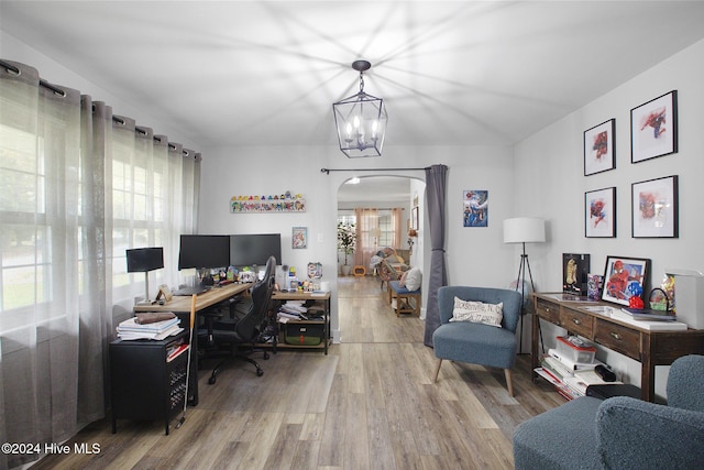 office area with hardwood / wood-style floors, a wealth of natural light, and an inviting chandelier