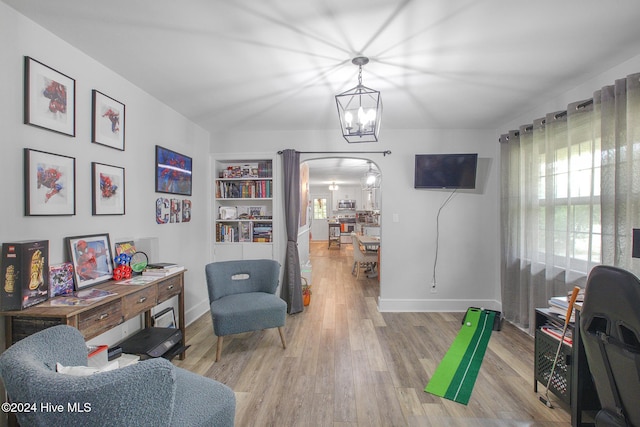 office with hardwood / wood-style flooring and an inviting chandelier