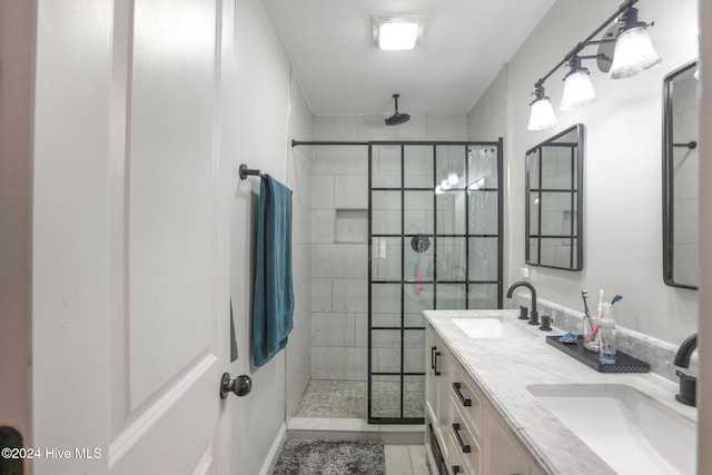 bathroom featuring tile patterned flooring, tiled shower, and vanity