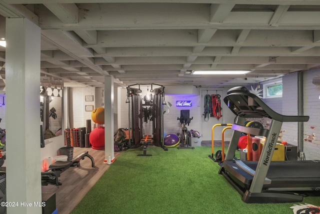 workout area featuring brick wall and carpet floors