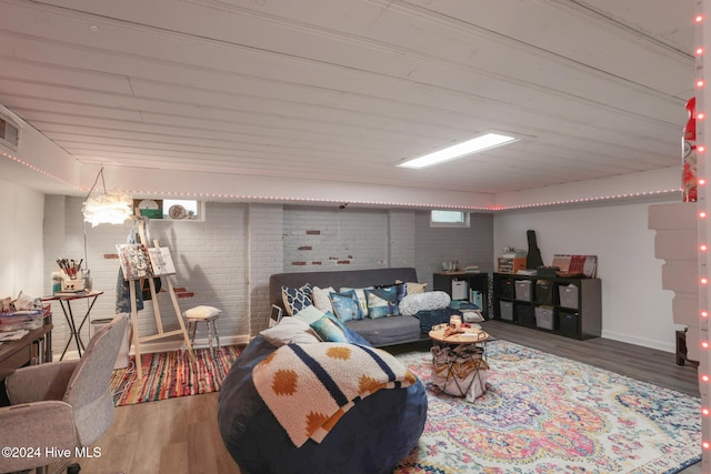 living room with hardwood / wood-style flooring and brick wall