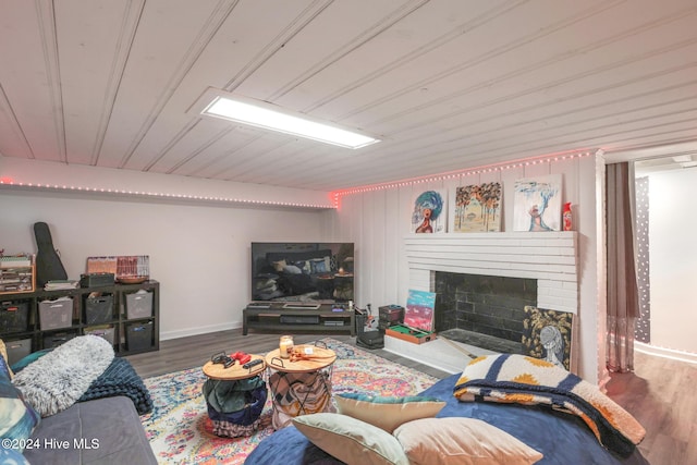 living room with hardwood / wood-style floors and a brick fireplace