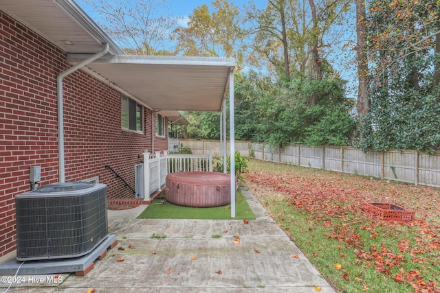 view of yard with a hot tub, central air condition unit, and a patio area