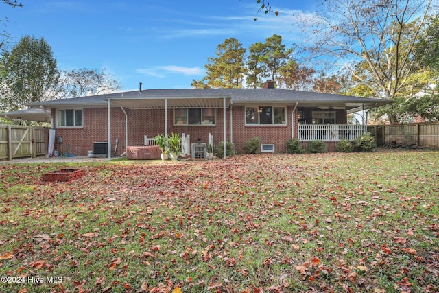 back of house featuring a hot tub, central AC unit, a patio, and a yard