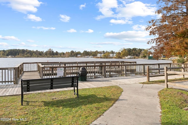 view of dock featuring a water view and a yard