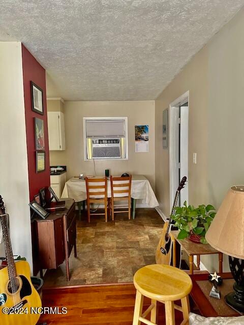 dining area featuring a textured ceiling, cooling unit, and dark hardwood / wood-style floors