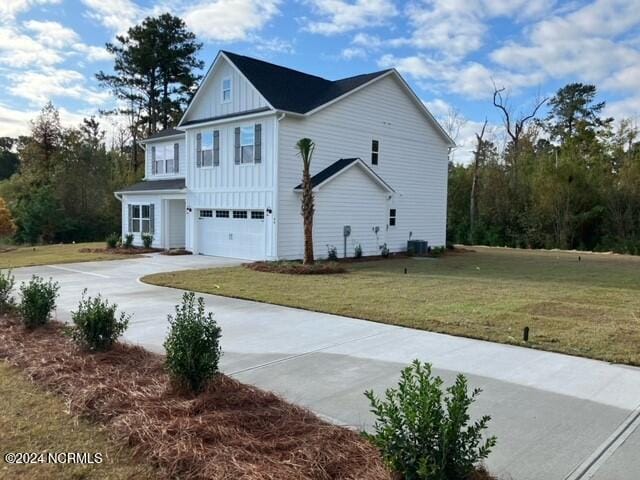 view of front facade with central AC, a front lawn, and a garage