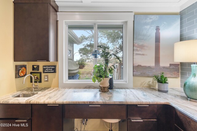 kitchen with hanging light fixtures, backsplash, sink, light wood-type flooring, and appliances with stainless steel finishes