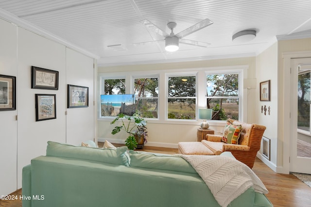 living room featuring light hardwood / wood-style flooring, ornamental molding, and ceiling fan