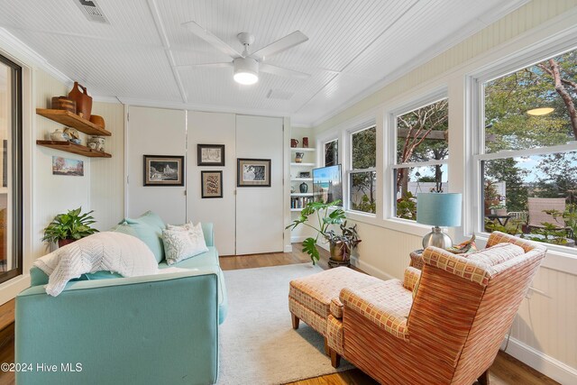 sunroom / solarium featuring a healthy amount of sunlight and ceiling fan