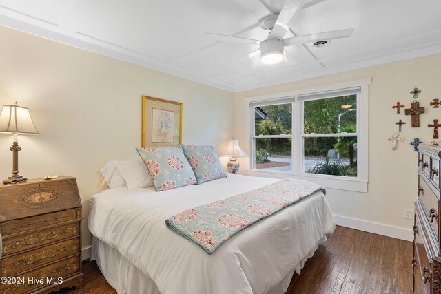 bedroom featuring ceiling fan, multiple windows, beamed ceiling, and dark hardwood / wood-style flooring