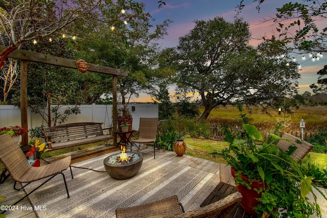 deck at dusk featuring a patio