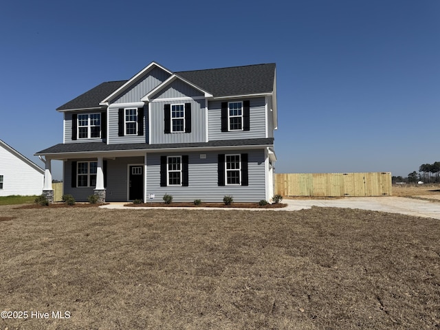 view of front of home with a front yard, fence, and board and batten siding