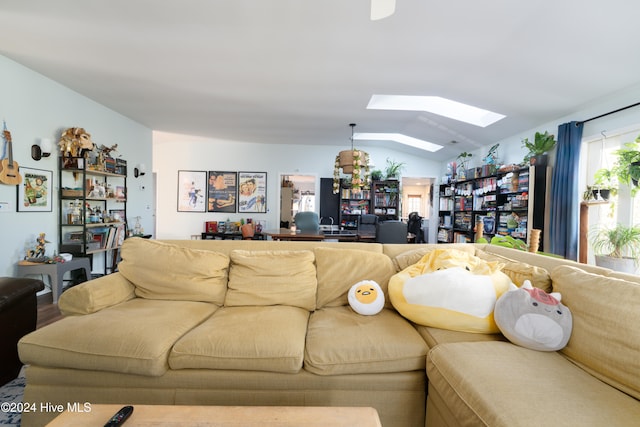 living room featuring lofted ceiling with skylight