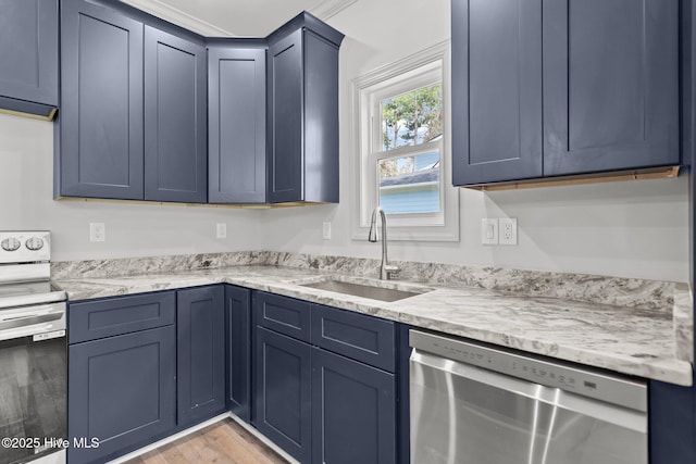 1552 Windsong Dr SW, Ocean Isle Beach, NC 28469 - kitchen featuring stainless steel appliances, a sink, light stone counters, light wood-style flooring, and blue cabinets