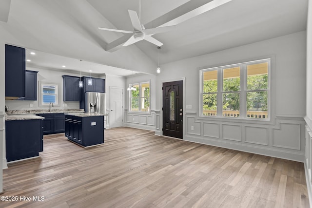 1552 Windsong Dr SW, Ocean Isle Beach, NC 28469 - kitchen featuring a decorative wall, a sink, a center island, ceiling fan, and blue cabinetry