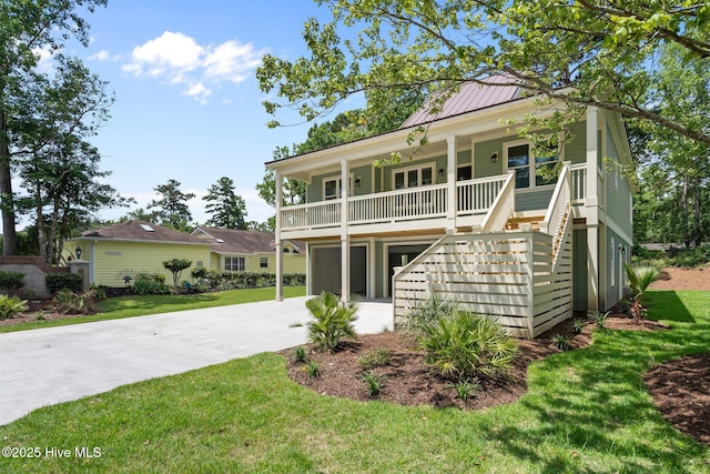 1552 Windsong Dr SW, Ocean Isle Beach, NC 28469 - beach home with concrete driveway, a porch, stairs, and a front yard