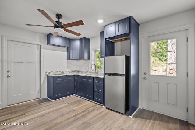 1552 Windsong Dr SW, Ocean Isle Beach, NC 28469 - kitchen with freestanding refrigerator, a ceiling fan, blue cabinets, plenty of natural light, and recessed lighting