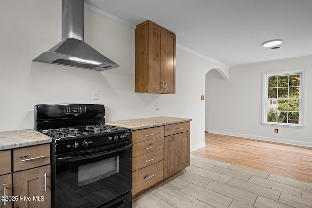 kitchen featuring crown molding, wall chimney exhaust hood, and black range with gas stovetop