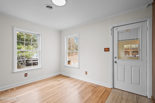 foyer entrance with light hardwood / wood-style floors and crown molding