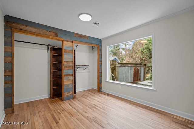 unfurnished bedroom with ornamental molding and light hardwood / wood-style floors