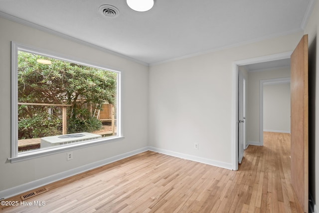 empty room with crown molding and light hardwood / wood-style flooring