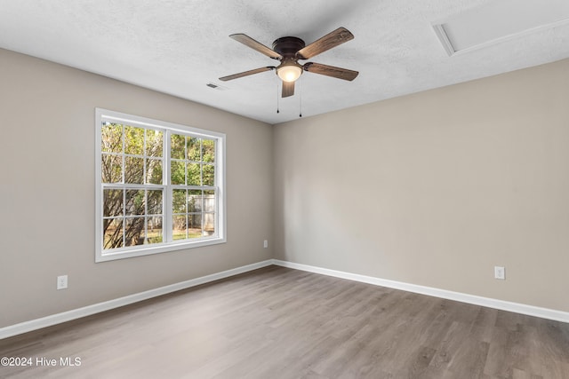 unfurnished room with a textured ceiling, hardwood / wood-style flooring, and ceiling fan